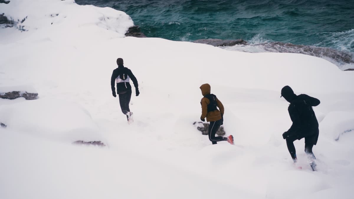 Three runners pushing through deep snow along the Bruce Peninsula coast